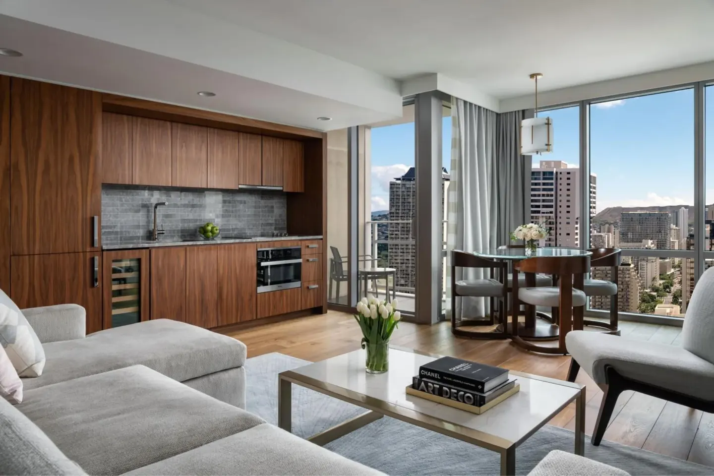Suite living area with kitchenette, round dining table, and city views at The Ritz-Carlton Residences, Waikiki Beach.