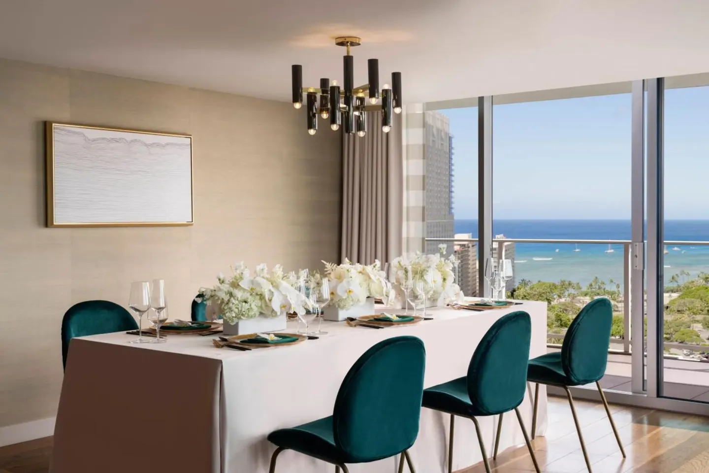 Private dining table at The Ritz-Carlton Residences, Waikiki Beach set beside windows overlooking the ocean.