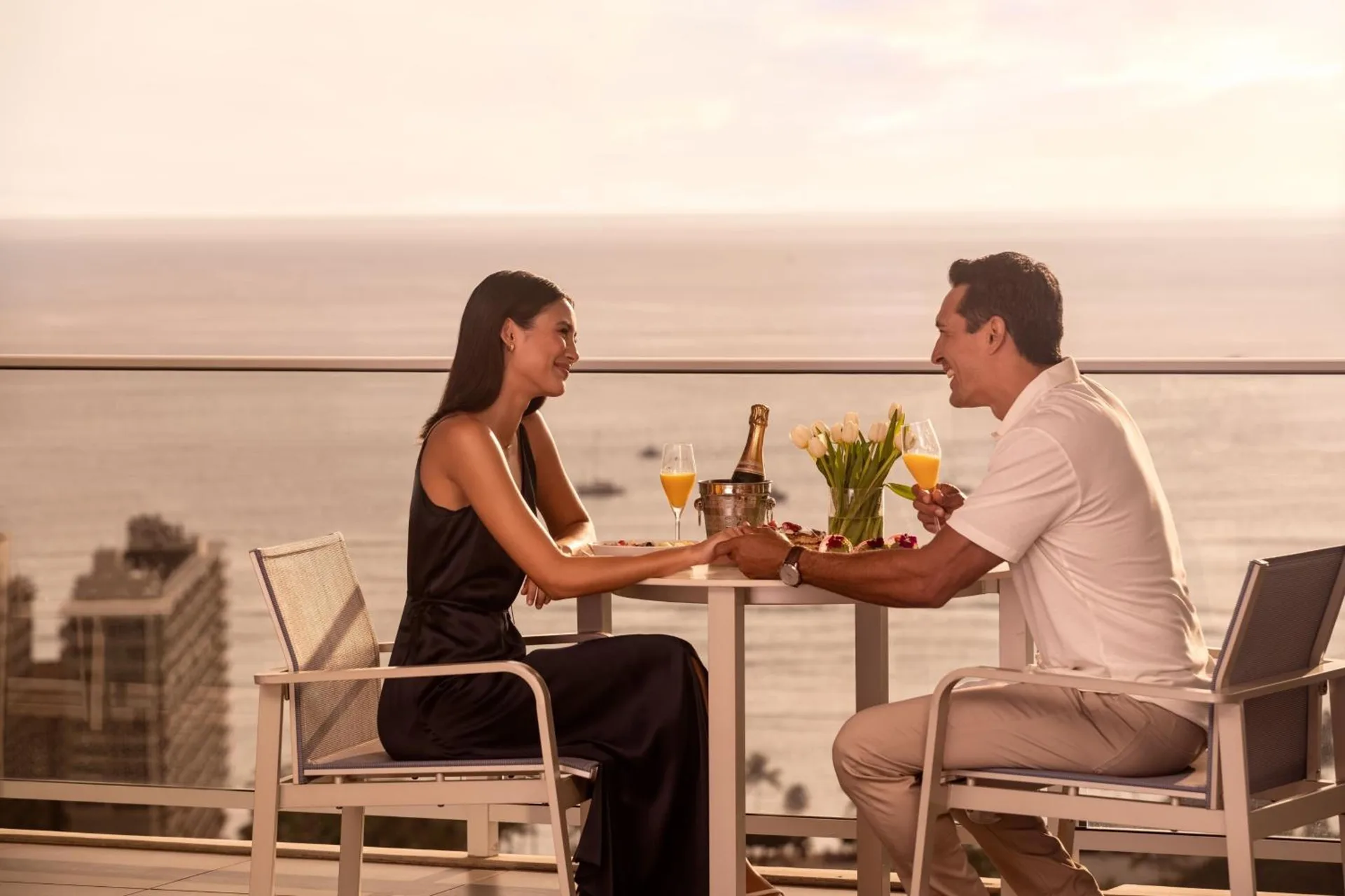 Couple dining on an ocean-view terrace at The Ritz-Carlton Residences, Waikiki Beach.