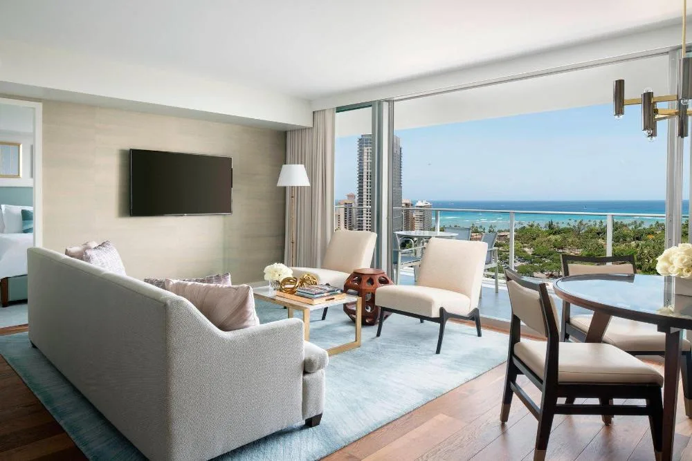 Grand Suite 1 Bedroom Ocean View living room at The Ritz-Carlton Residences, Waikiki Beach with elegant furnishings, full kitchen, and Pacific Ocean views from private lanai.