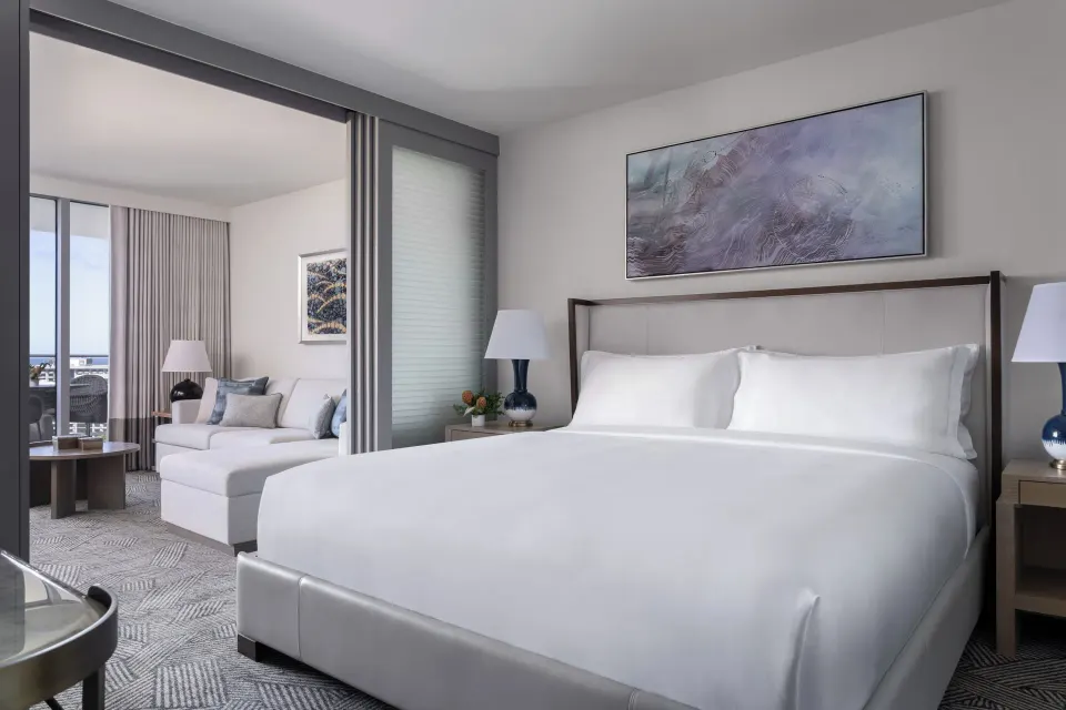 Deluxe Suite bedroom with king bed and sitting area at The Ritz-Carlton Residences, Waikiki Beach.