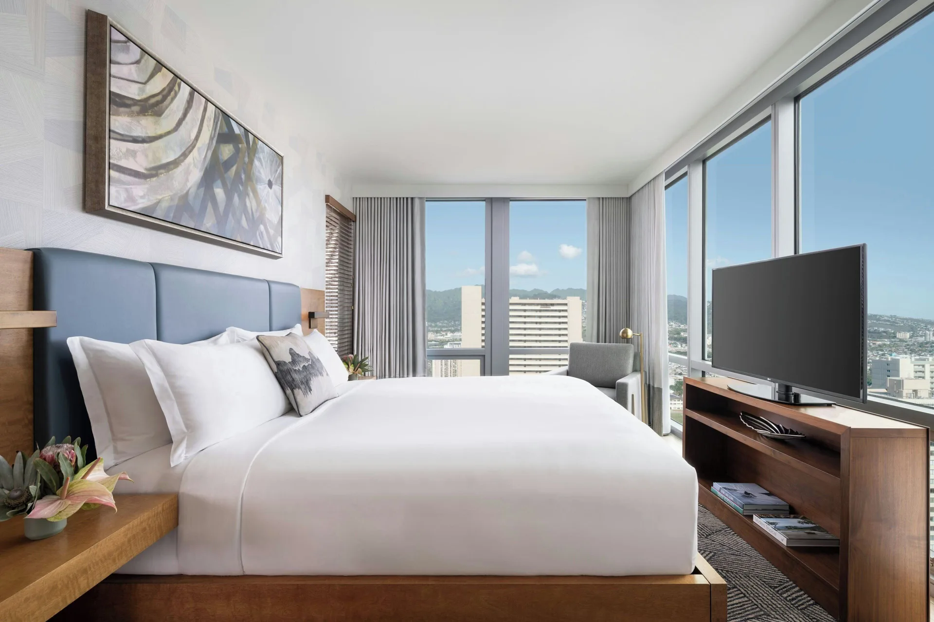 Sky Three-Bedroom Suite bedroom with city view windows at The Ritz-Carlton Residences, Waikiki Beach.