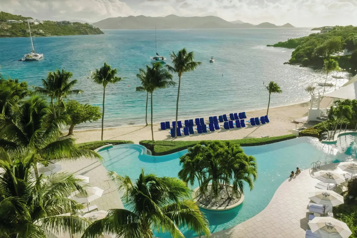 Aerial view of the pool, beach, palms, and turquoise bay at The Ritz-Carlton, St. Thomas.