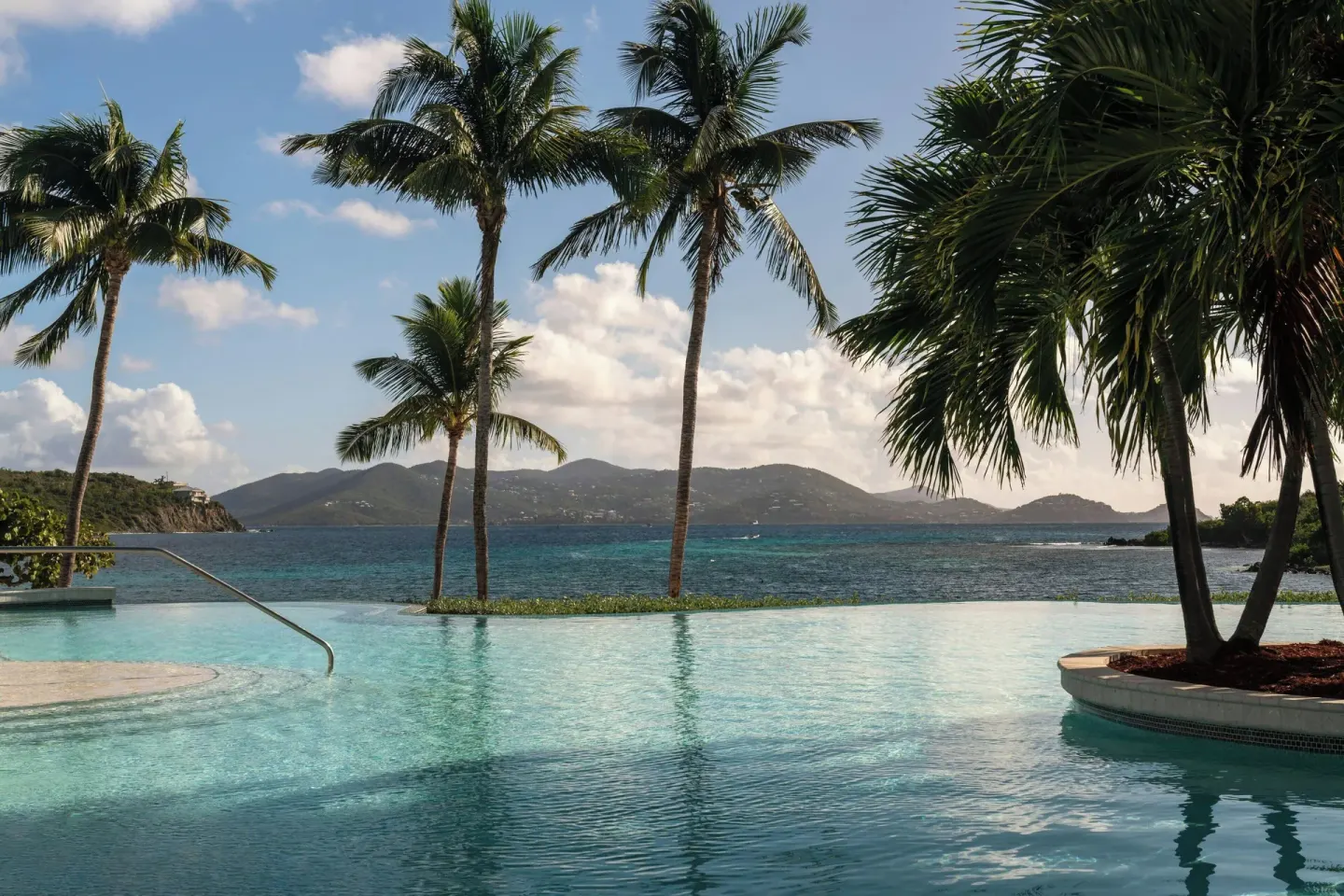 Infinity pool with palm trees and island views at The Ritz-Carlton, St. Thomas.