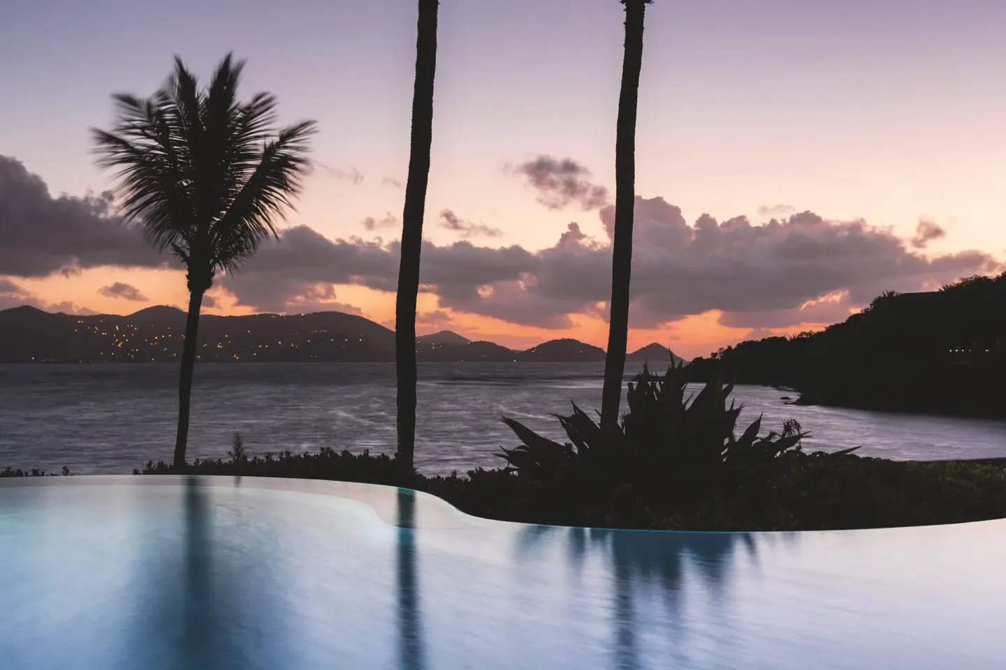 Infinity pool and palm silhouettes at sunset at The Ritz-Carlton, St. Thomas.