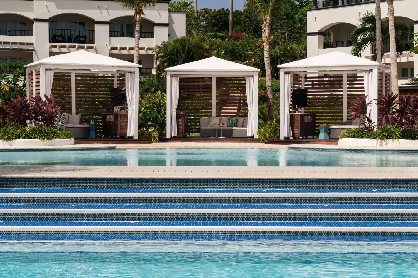 White pool cabanas face blue tile steps at The Ritz-Carlton, St. Thomas.