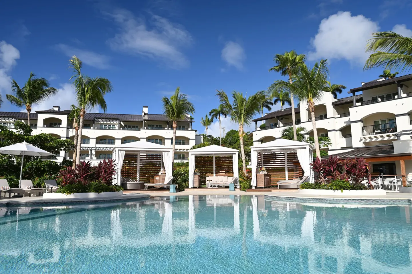 Pool surface reflecting cabanas, palms, and resort buildings at The Ritz-Carlton, St. Thomas.