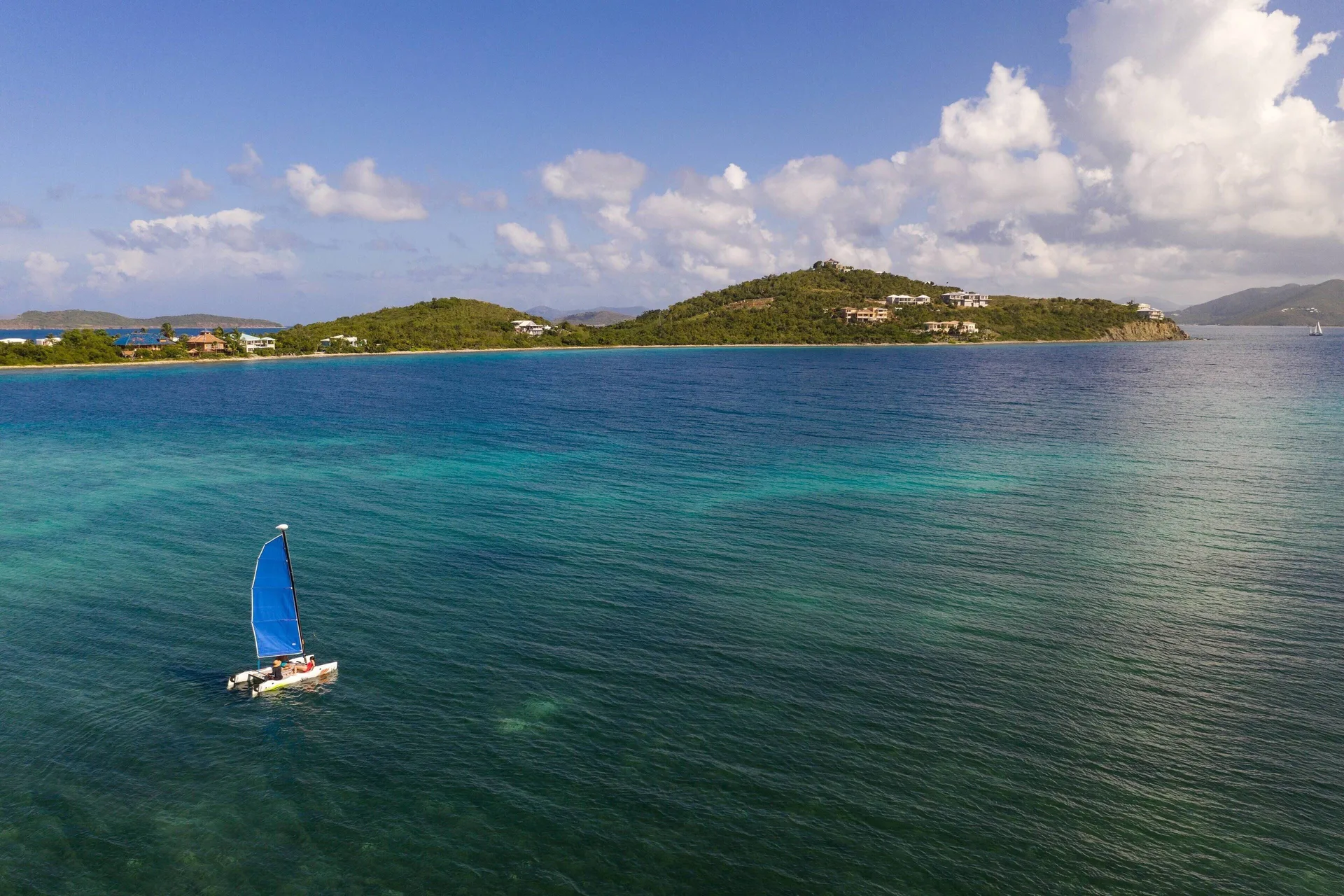 Small sailboat on clear blue water near The Ritz-Carlton, St. Thomas.