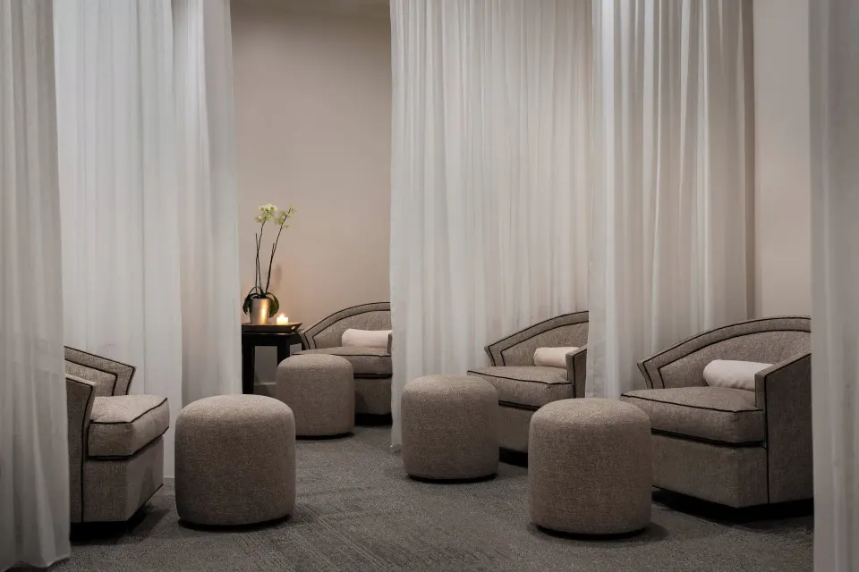 Spa lounge chairs with white curtains and ottomans at The Ritz-Carlton, St. Thomas.