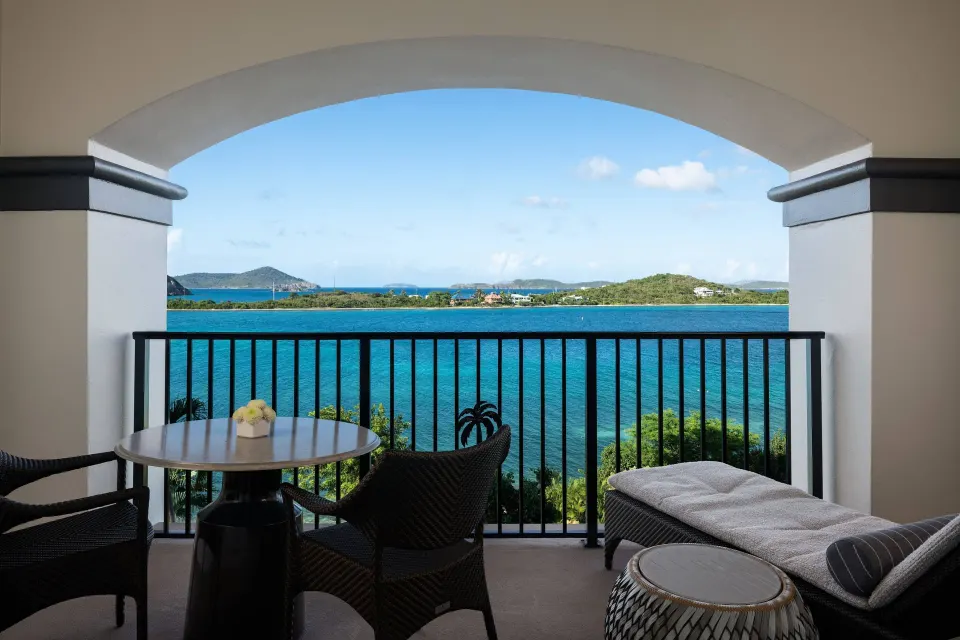 Club Oceanfront Room balcony with lounge seating and blue bay view at The Ritz-Carlton, St. Thomas.