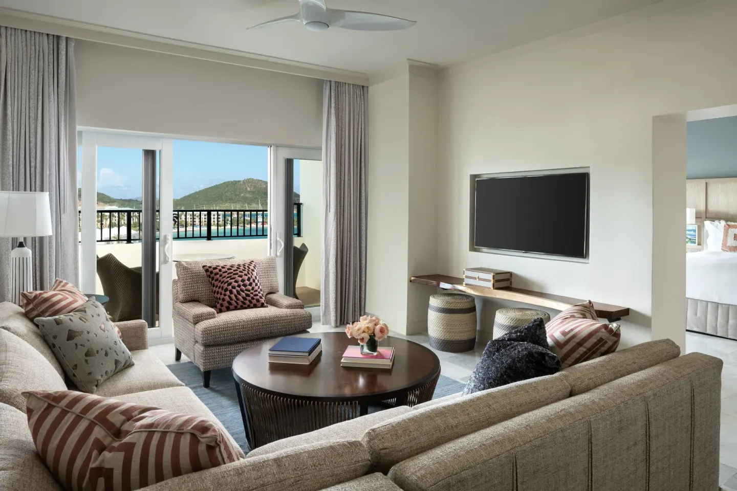 Executive Suite living room at The Ritz-Carlton, St. Thomas with sofas, TV and balcony view.