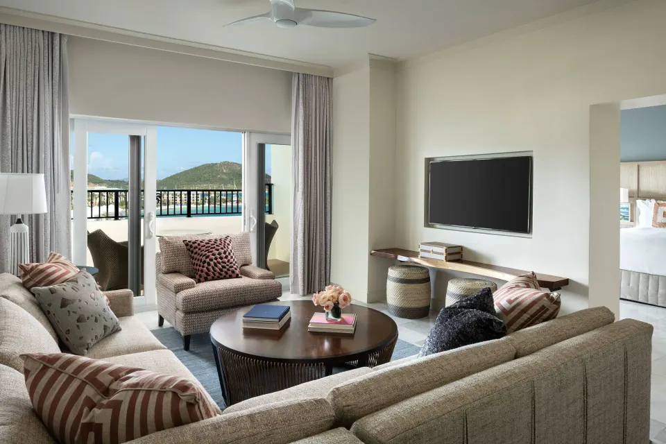 Executive Suite living room at The Ritz-Carlton, St. Thomas with sofas, TV and balcony view.