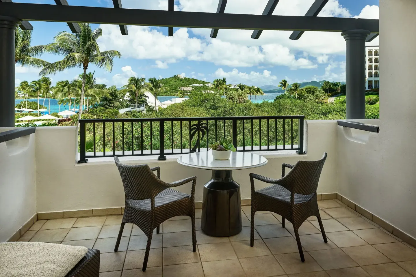 Covered Resort View Room balcony with chairs and water views at The Ritz-Carlton, St. Thomas.