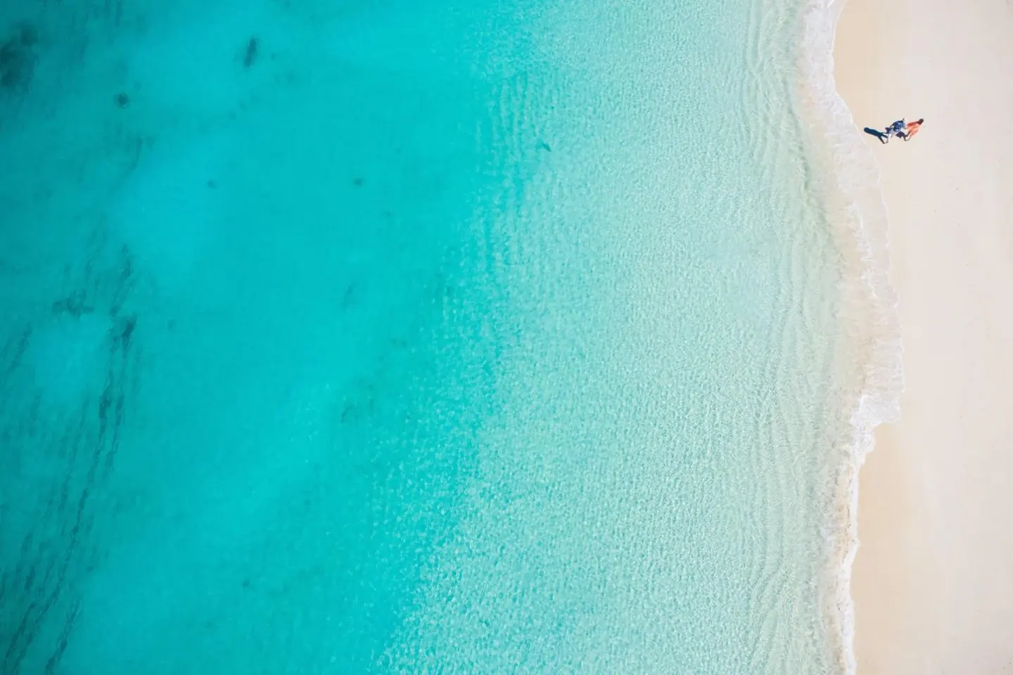 Aerial view of turquoise water meeting white sand at The Ritz-Carlton, Turks & Caicos.