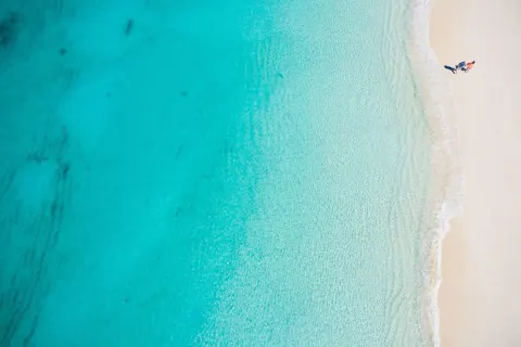 Aerial view of turquoise water meeting white sand at The Ritz-Carlton, Turks & Caicos.