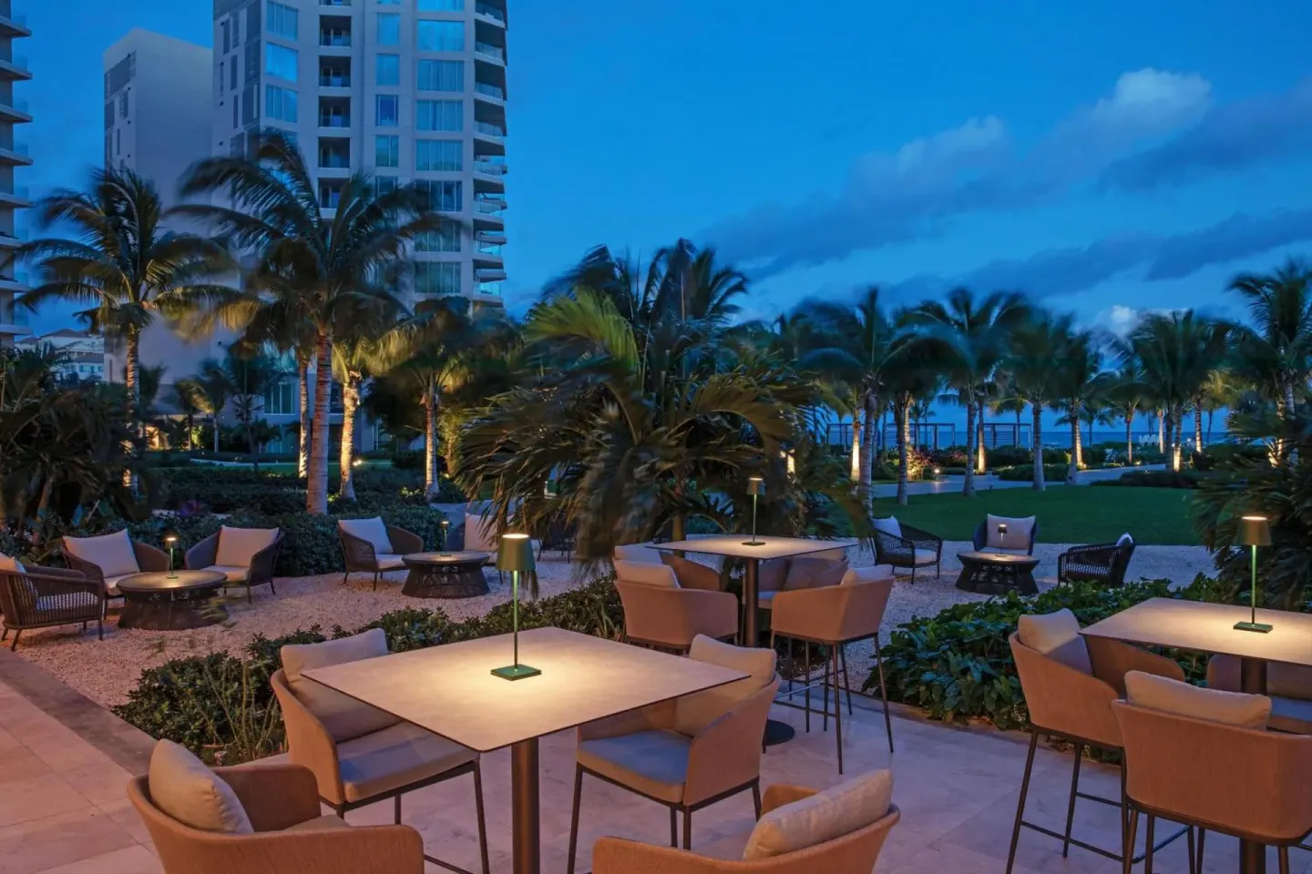 Evening terrace seating among palm trees at The Ritz-Carlton, Turks & Caicos.