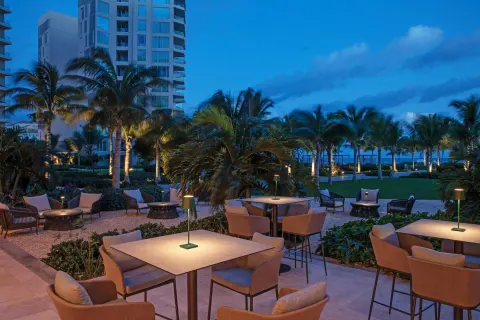 Evening terrace seating among palm trees at The Ritz-Carlton, Turks & Caicos.