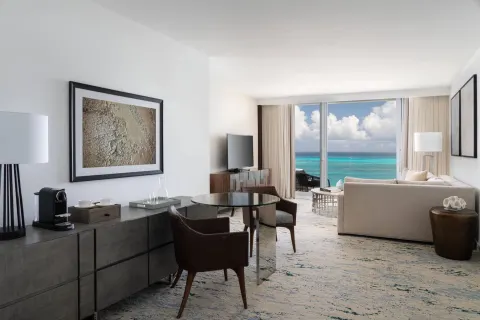 Ocean-view suite living area with dining table at The Ritz-Carlton, Turks & Caicos.