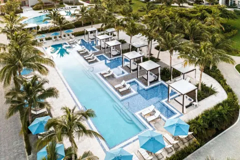 Aerial view of the resort pool with cabanas and palms at The Ritz-Carlton, Turks & Caicos.
