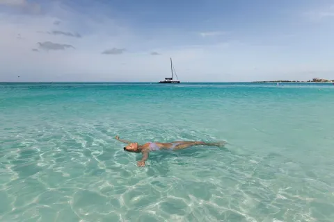 A swimmer floats in clear turquoise water near The Ritz-Carlton, Turks & Caicos.