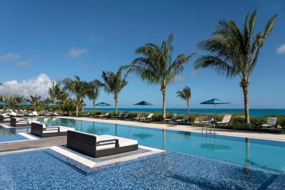 Oceanfront pool with palms and loungers at The Ritz-Carlton, Turks & Caicos.