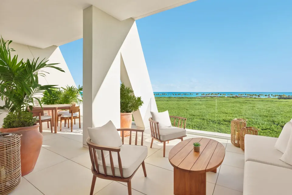 Covered terrace with lounge seating and ocean view at The Riviera Maya EDITION At Kanai.