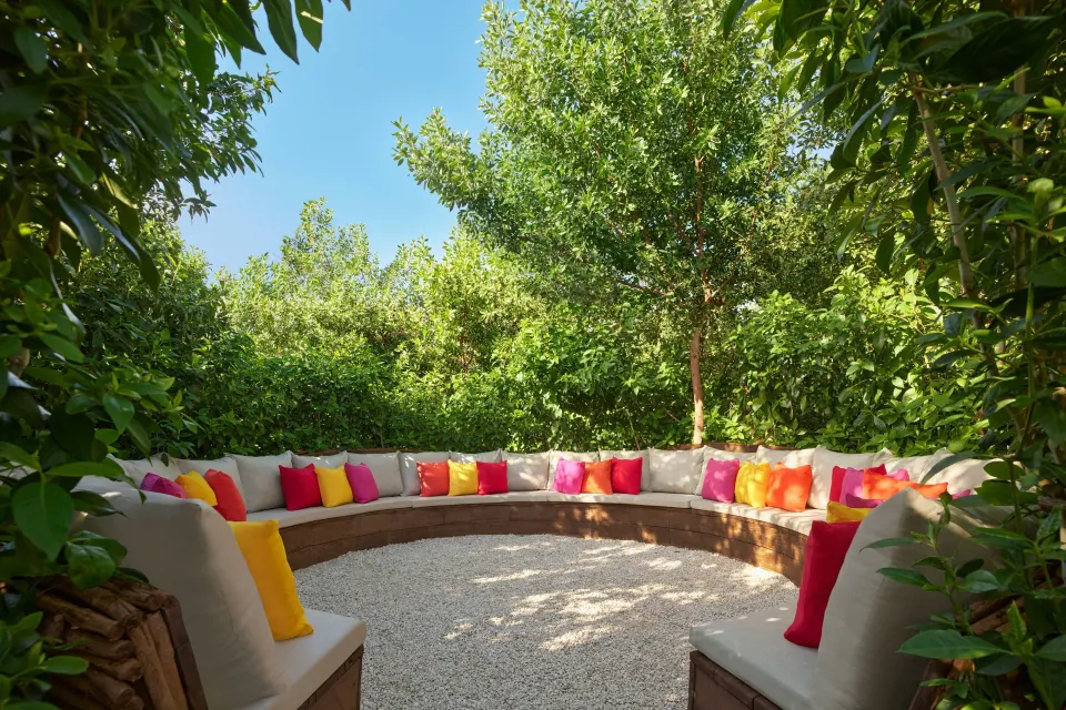 A circular garden lounge with colorful pillows at The Riviera Maya EDITION At Kanai.