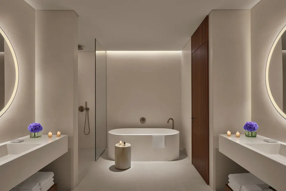 Symmetrical guest bathroom with tub and dual vanities at The Riviera Maya EDITION At Kanai.
