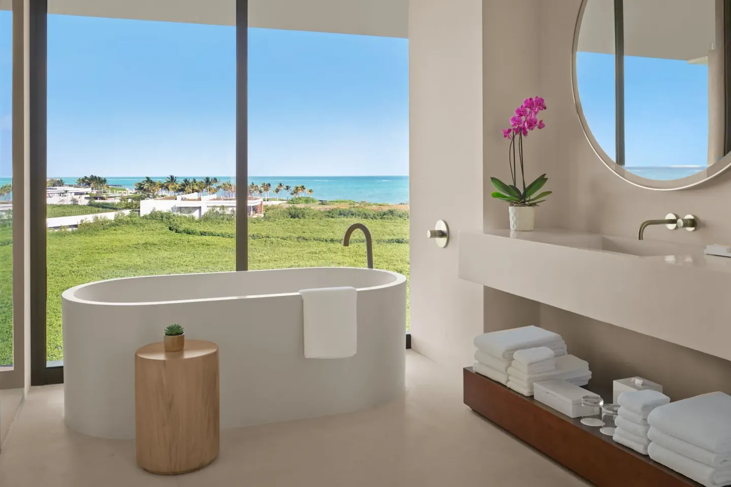 Bathroom tub beside windows with ocean view at The Riviera Maya EDITION At Kanai.