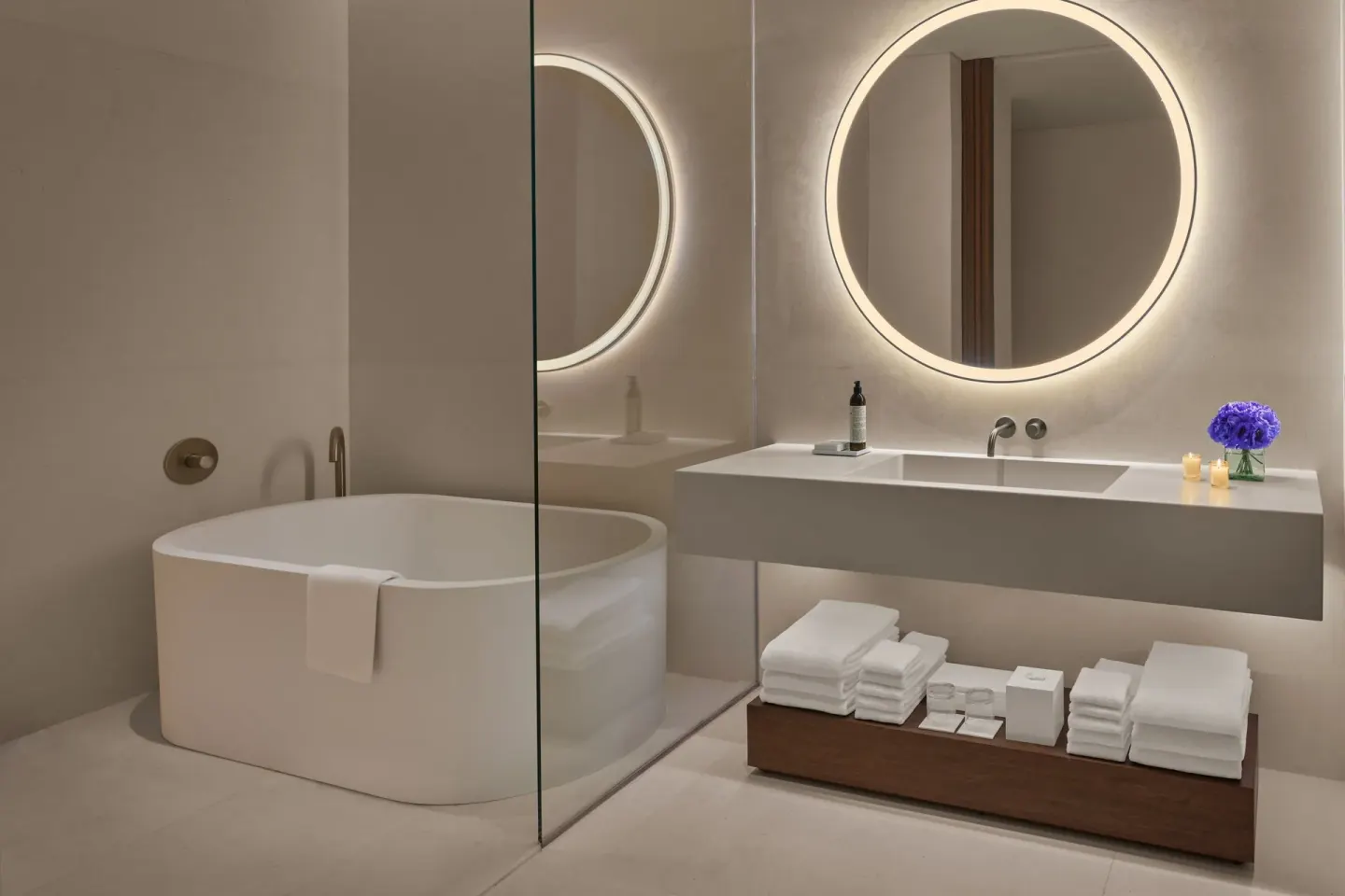 Guest bathroom with soaking tub and lit mirror at The Riviera Maya EDITION At Kanai.