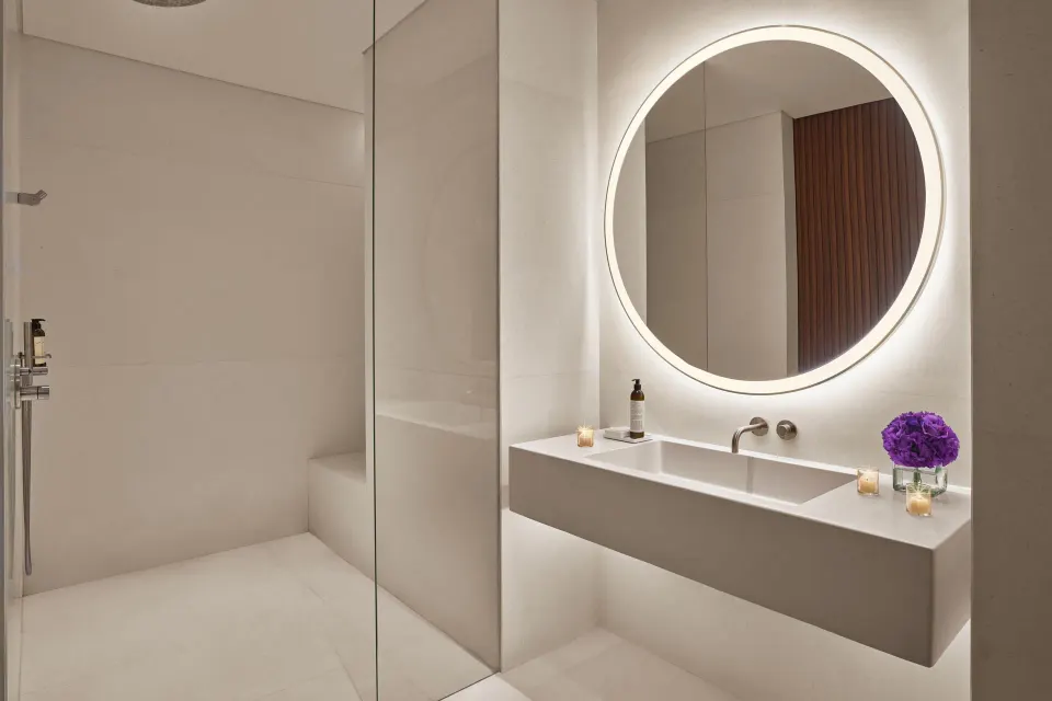 Guest bathroom vanity beside glass shower at The Riviera Maya EDITION At Kanai.