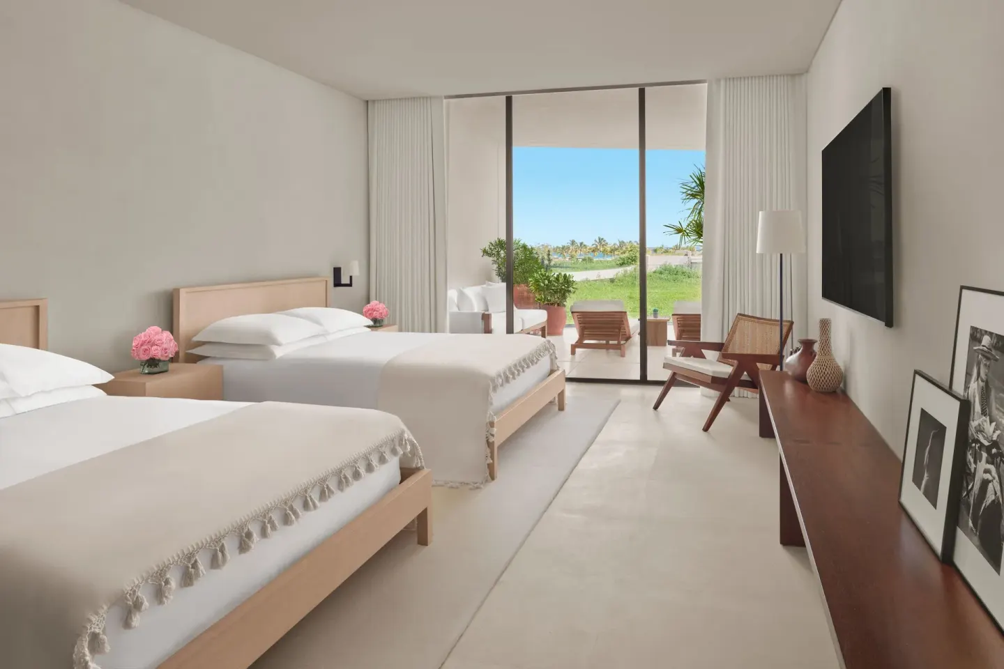 Bright two-bed guest room at The Riviera Maya EDITION At Kanai with terrace and lagoon view.