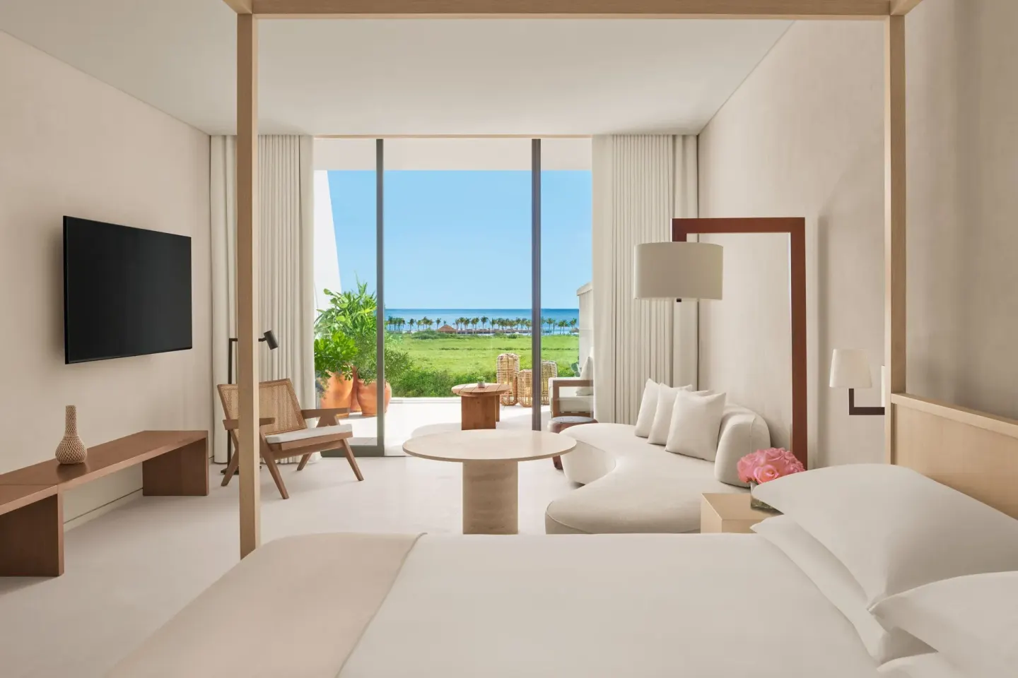 King-bed suite at The Riviera Maya EDITION At Kanai with sitting area and ocean view.