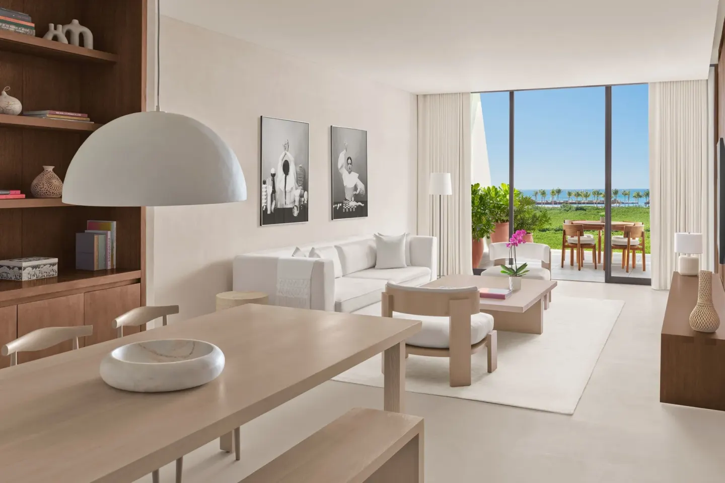 Suite living room with dining table and terrace view at The Riviera Maya EDITION At Kanai.