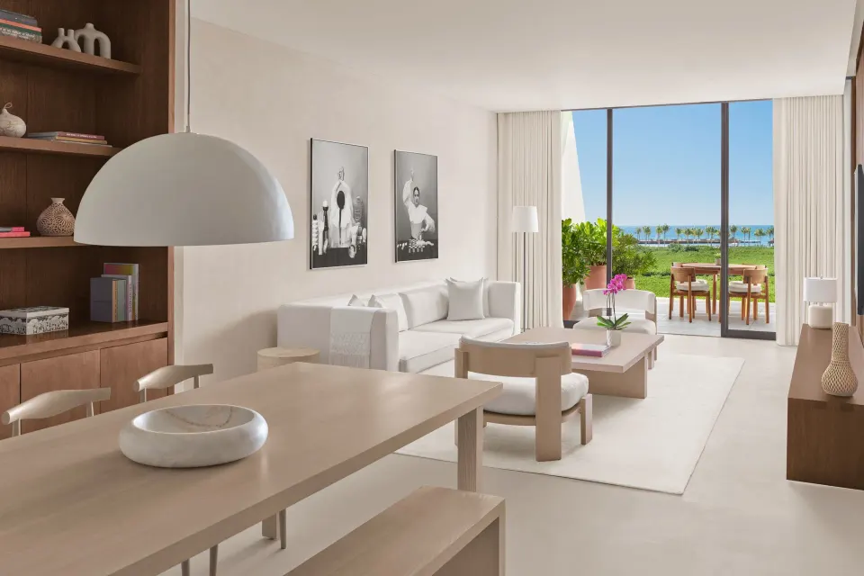 Suite living room with dining table and terrace view at The Riviera Maya EDITION At Kanai.