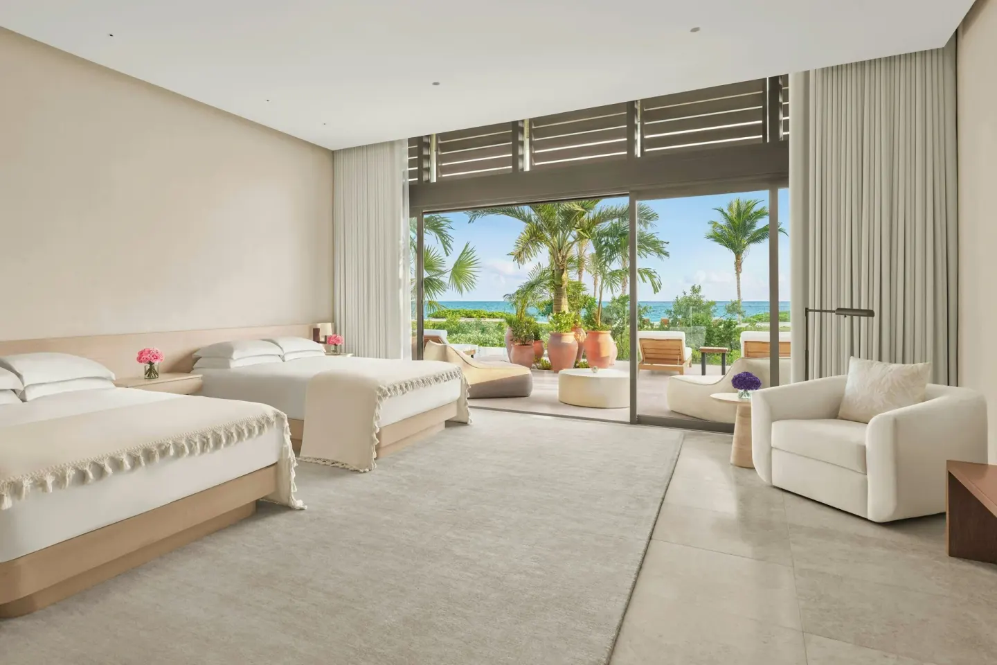 Two queen beds in a guest room with terrace at The Riviera Maya EDITION At Kanai.