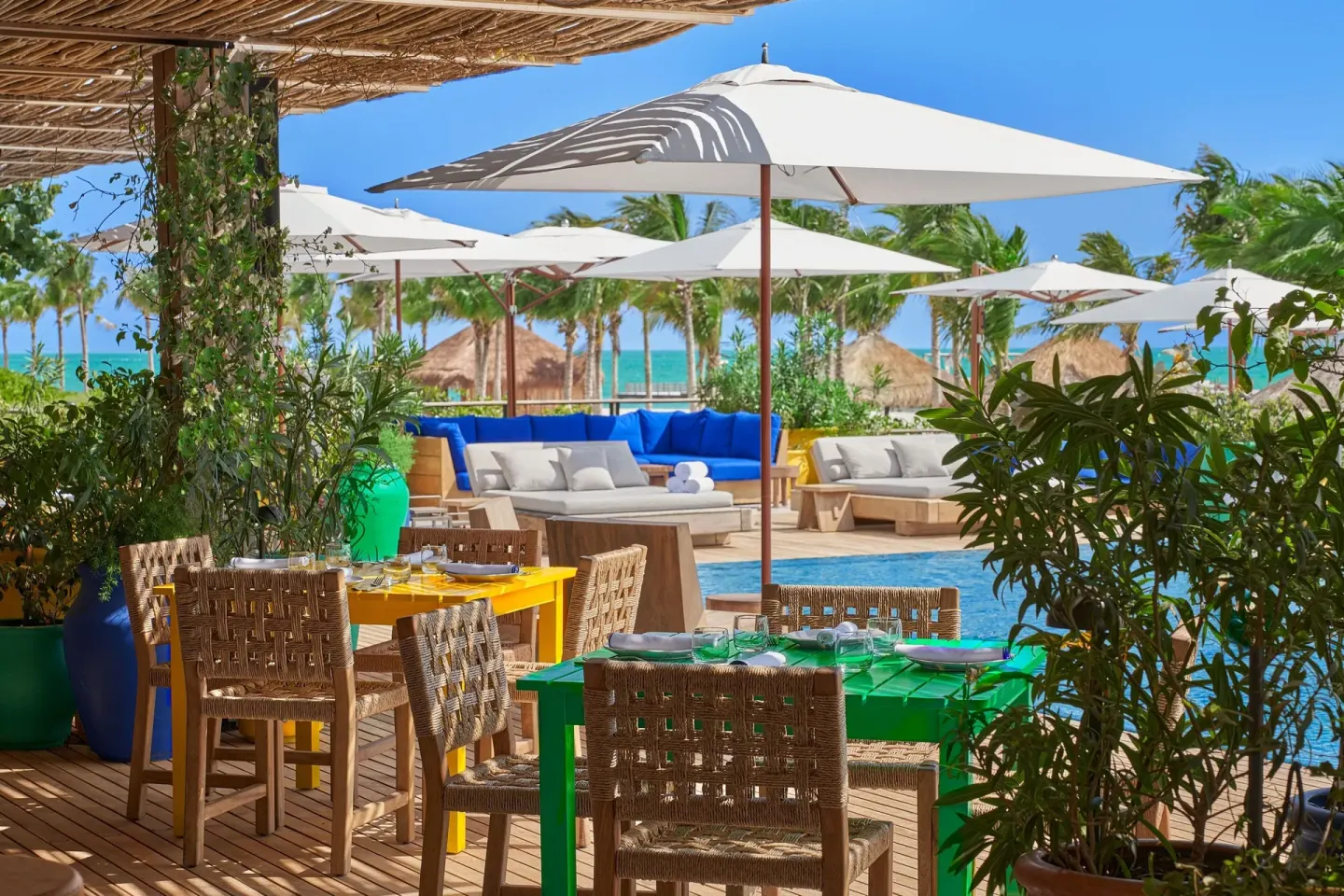 Colorful poolside dining tables at The Riviera Maya EDITION At Kanai.