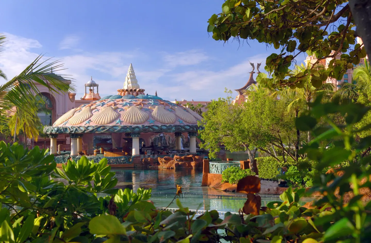 Shell-topped pavilion and waterway framed by tropical greenery at The Royal at Atlantis.