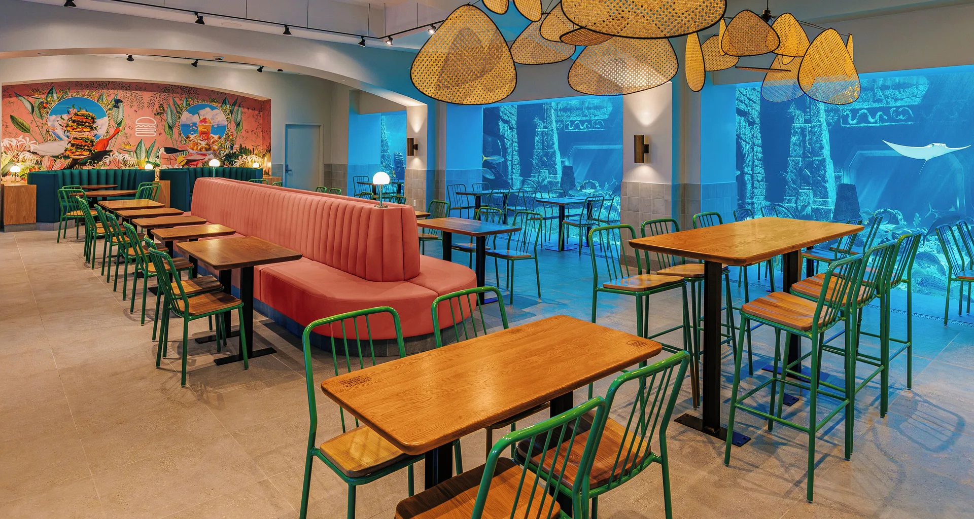 A casual dining room overlooks aquarium windows at The Royal at Atlantis.