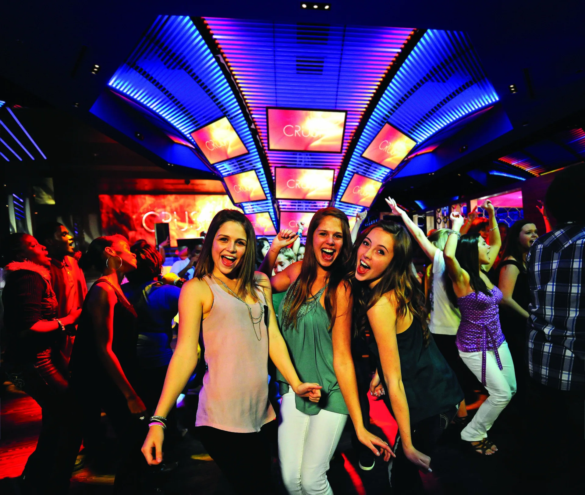 Guests dance under colorful club lights at The Royal at Atlantis.