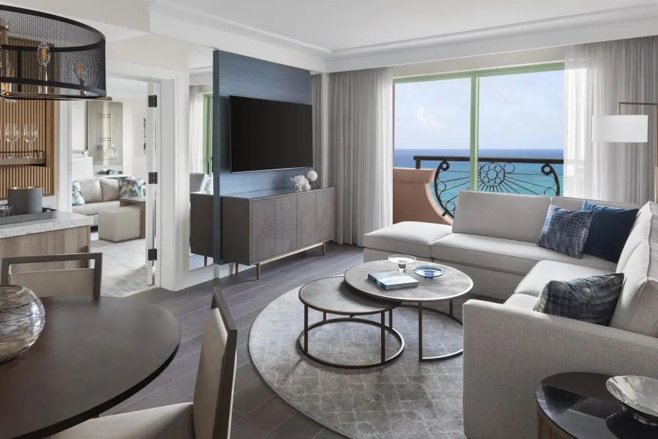 1 Bedroom Regal Suite living room with sectional sofa and ocean-view balcony at The Royal at Atlantis.