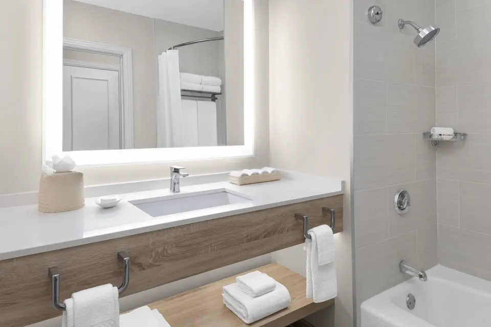 Terrace View bathroom with illuminated mirror, vanity, and bathtub at The Royal at Atlantis.