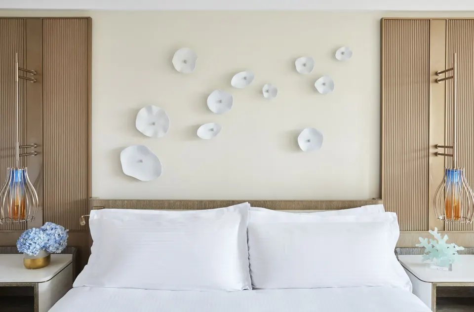 Terrace View guest room bed with white pillows and wall decor at The Royal at Atlantis.