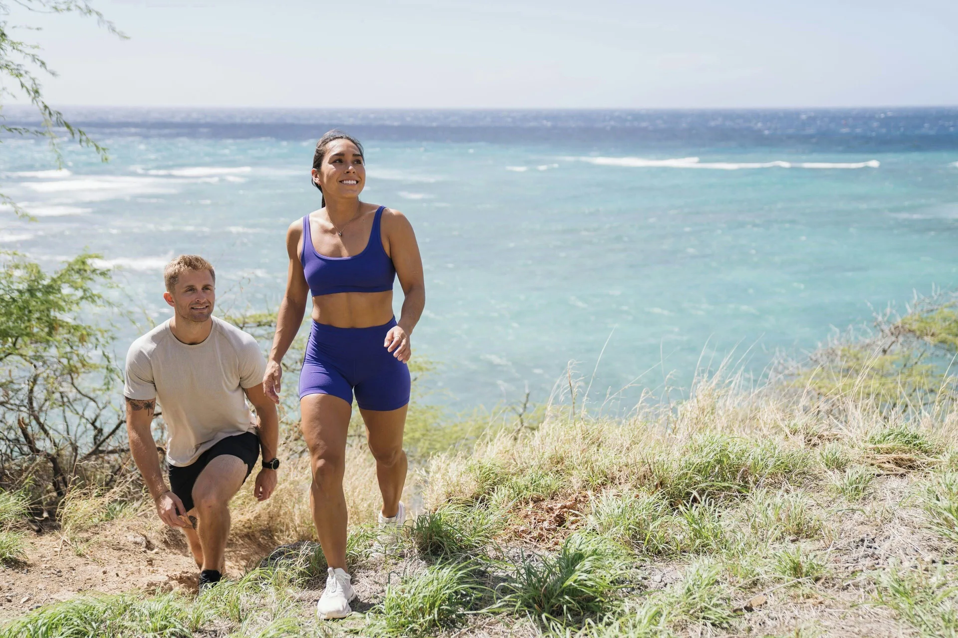 Two hikers climb a coastal trail above the ocean near The Royal Hawaiian, Waikiki.