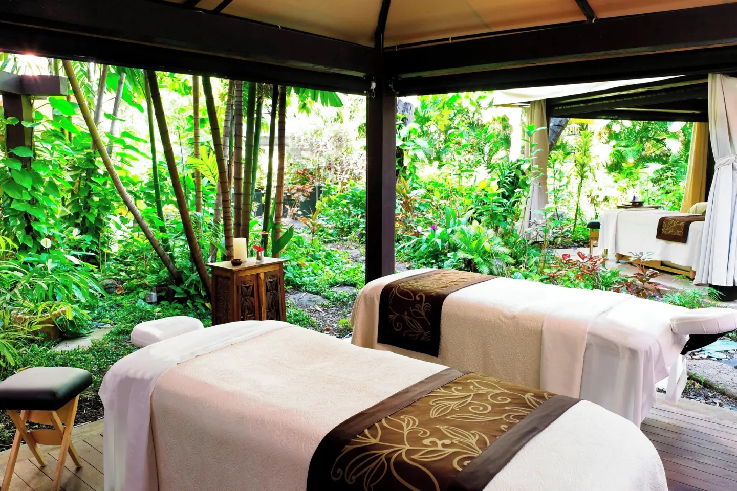 Two open-air spa treatment tables in a garden cabana at The Royal Hawaiian, Waikiki.