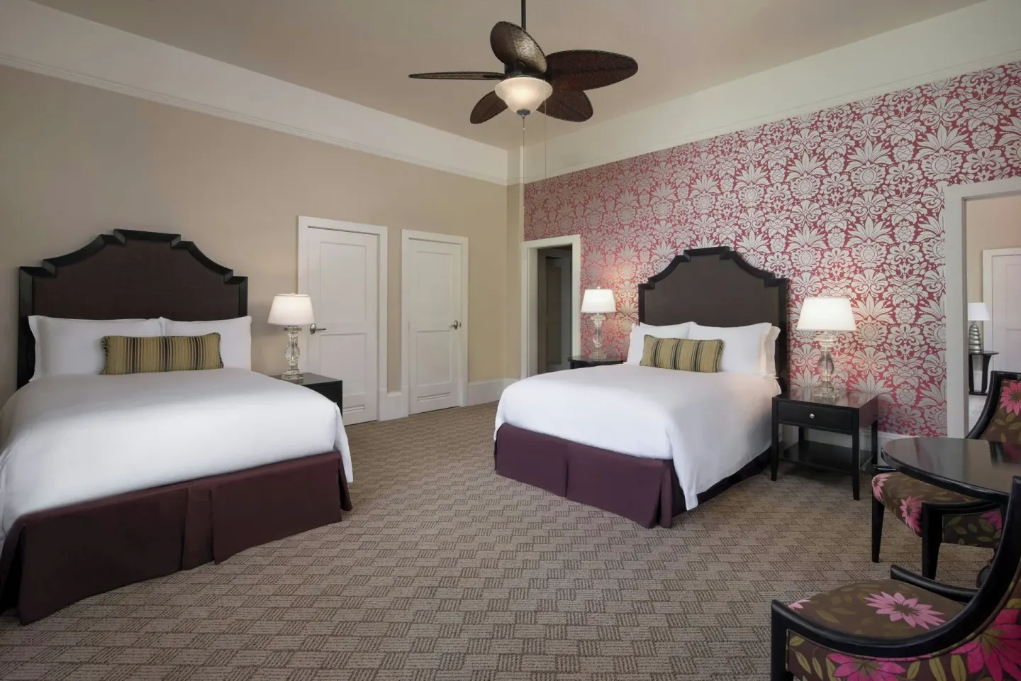 Two-bed guest room with red patterned wall at The Royal Hawaiian, Waikiki.