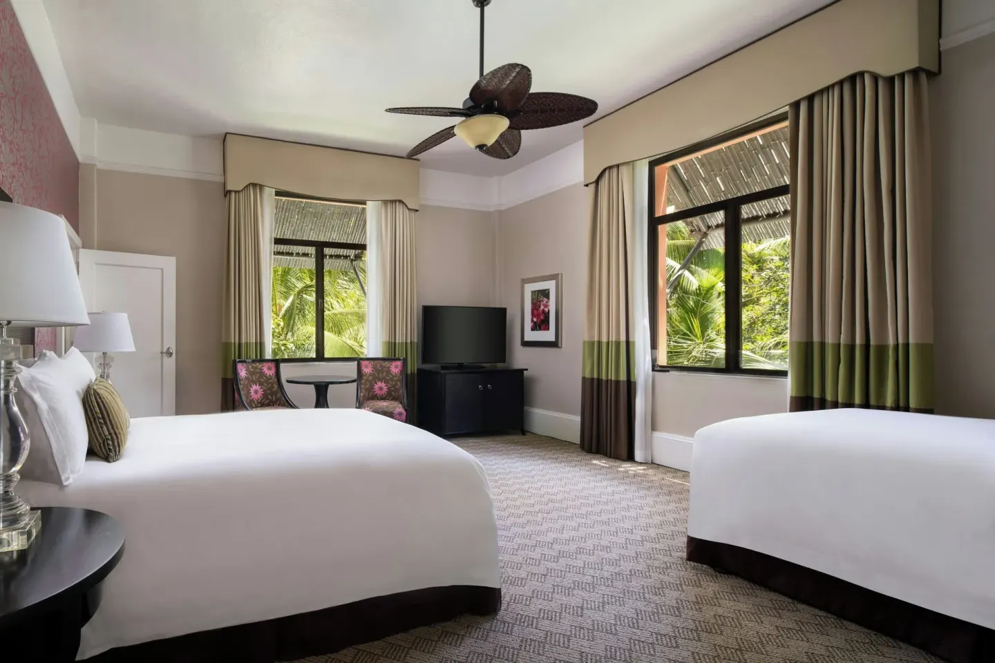 Two-bed guest room with tropical window views at The Royal Hawaiian, Waikiki.