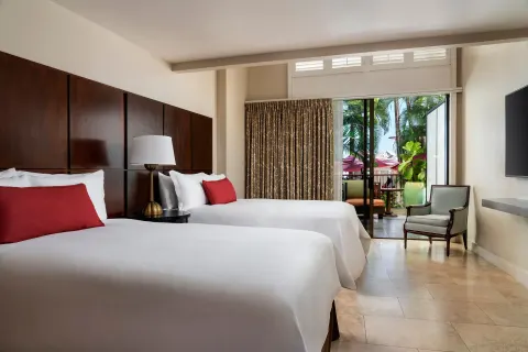 Two beds in a guest room with a lanai at The Royal Hawaiian, Waikiki.