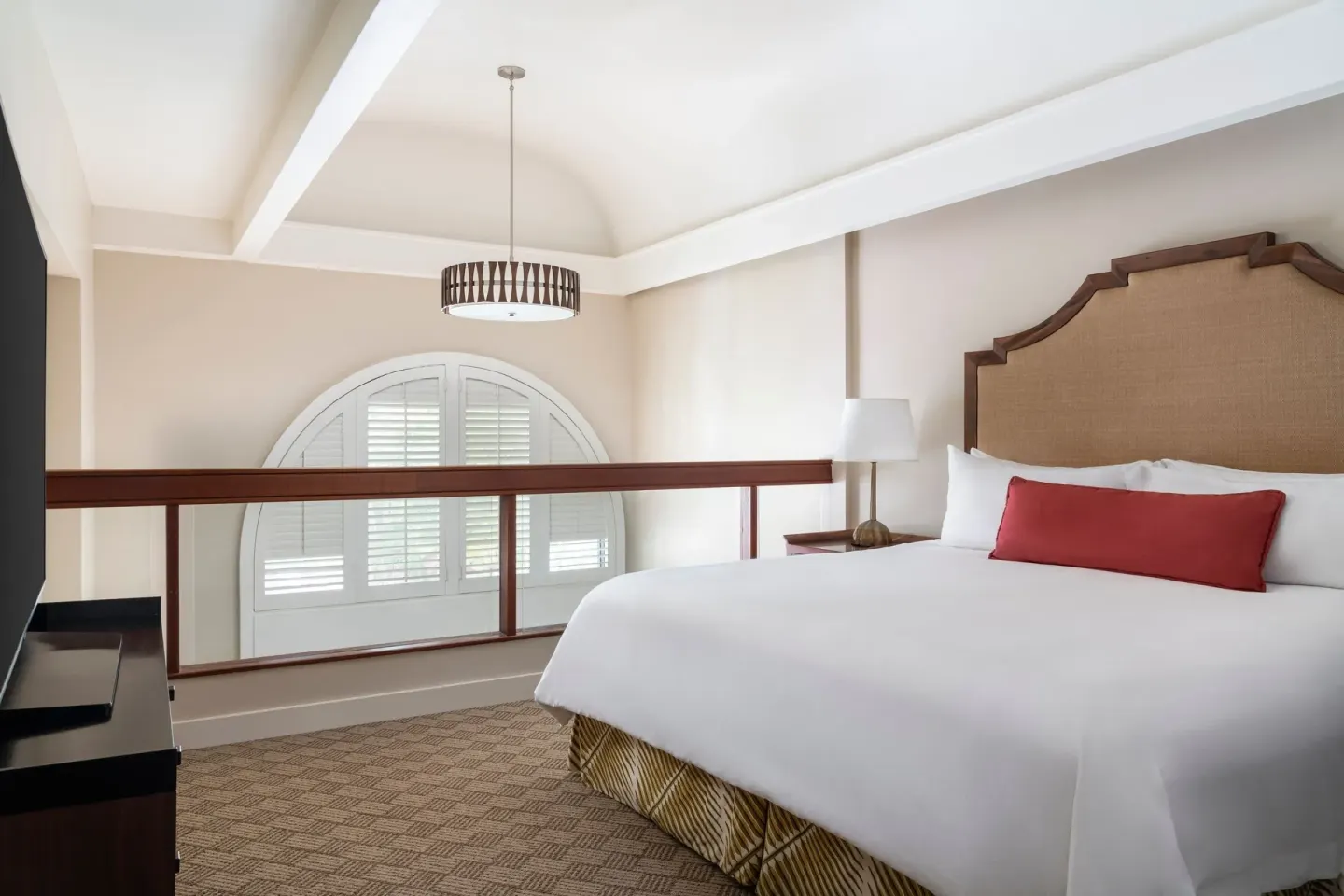 Loft-style king bed and arched shutters at The Royal Hawaiian, Waikiki.