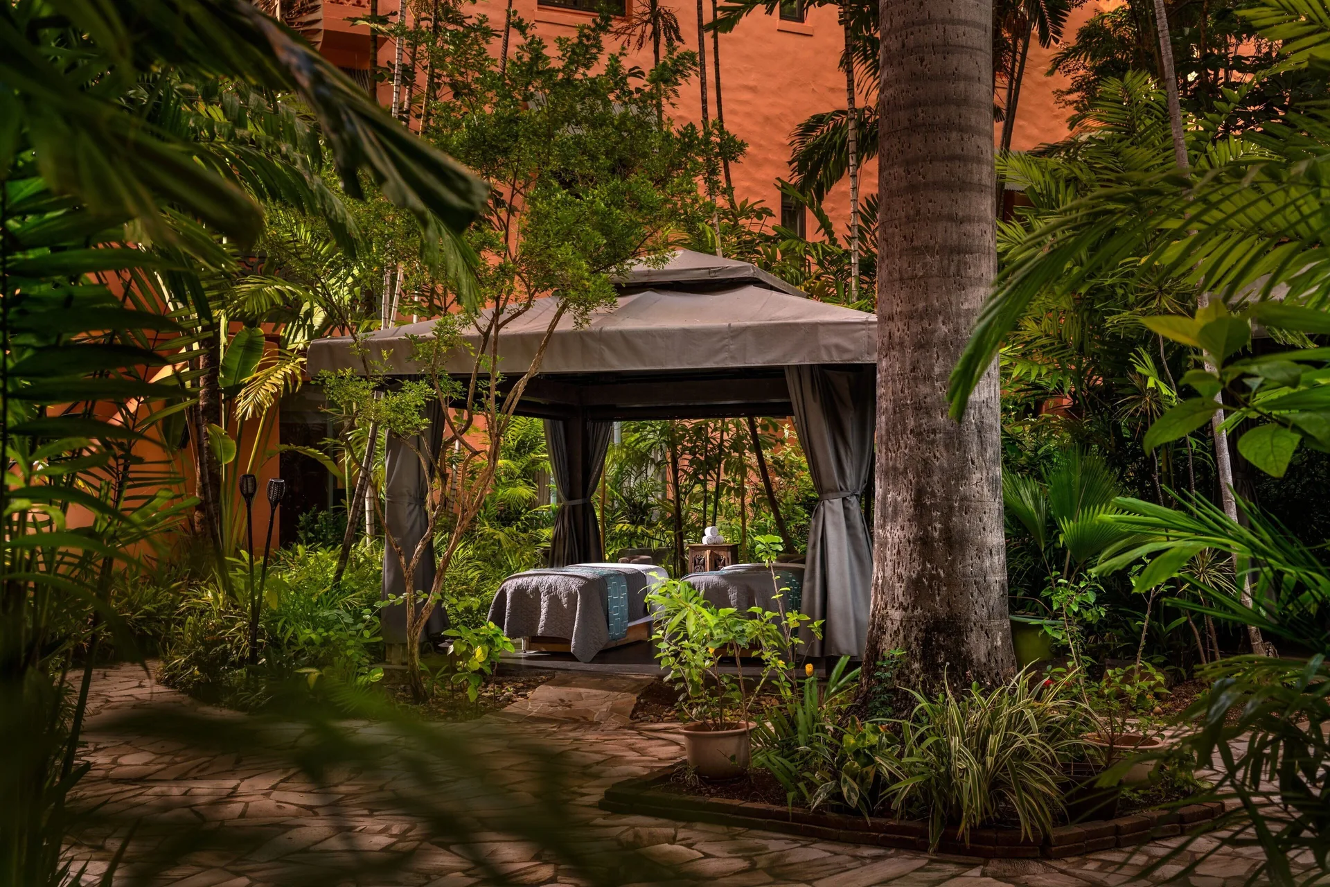 Outdoor spa cabana set in tropical gardens at The Royal Hawaiian, Waikiki.